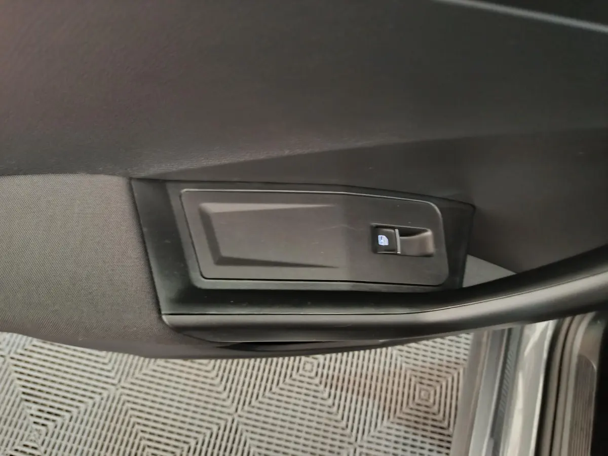 Gros plan sur la commande de verrouillage de porte côté gauche dans l'habitacle gris foncé du Volkswagen T-Roc 2021.