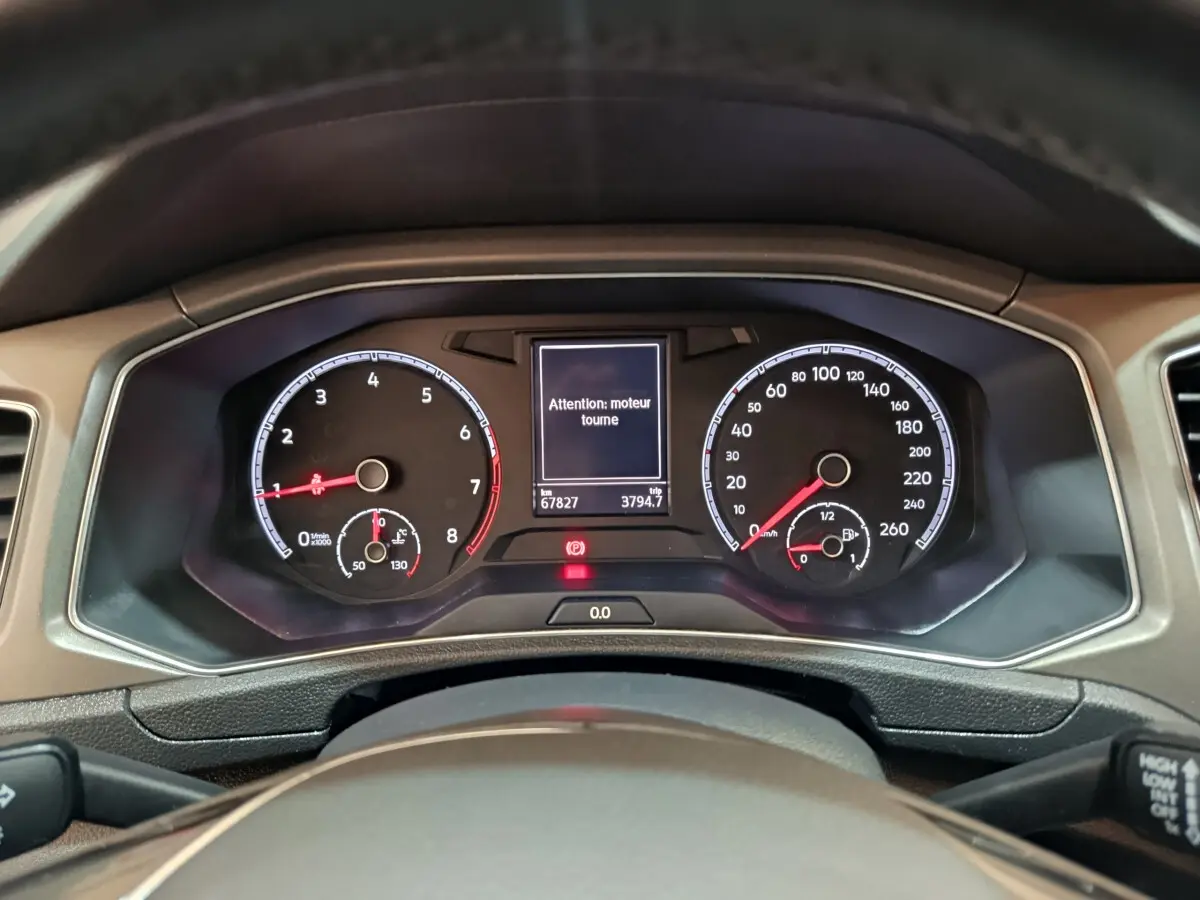 Vue rapprochée du tableau de bord numérique du Volkswagen T-Roc 2021, affichant un avertissement moteur.