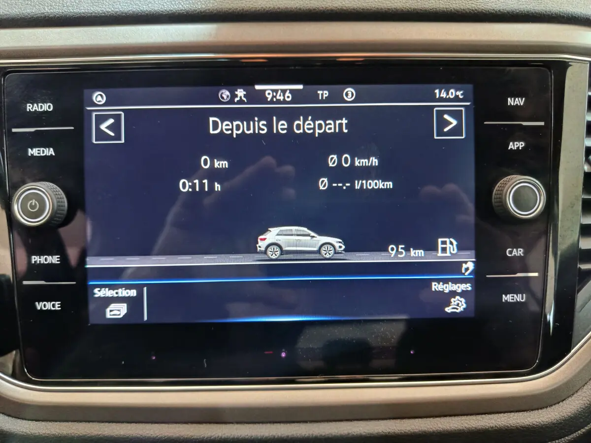 Écran tactile central affichant les données de trajet du Volkswagen T-Roc gris foncé en vue latérale droite.