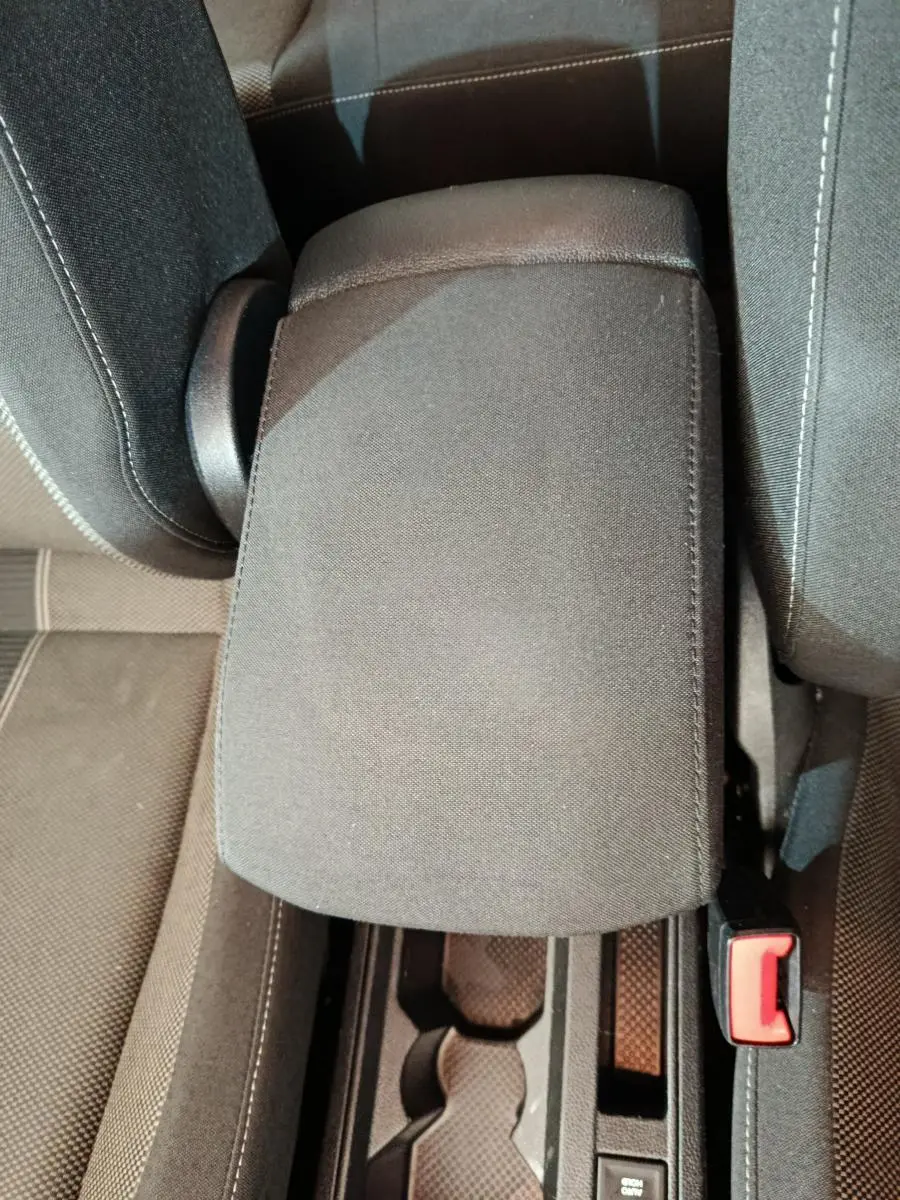 Vue plongeante sur l'accoudoir central gris foncé et la console entre les sièges avant du Volkswagen T-Roc 2021.