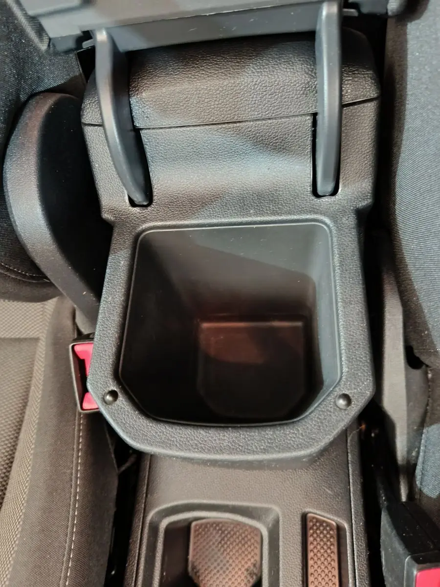 Gros plan sur le rangement central noir ouvert entre les sièges avant du Volkswagen T-Roc gris foncé 2021.