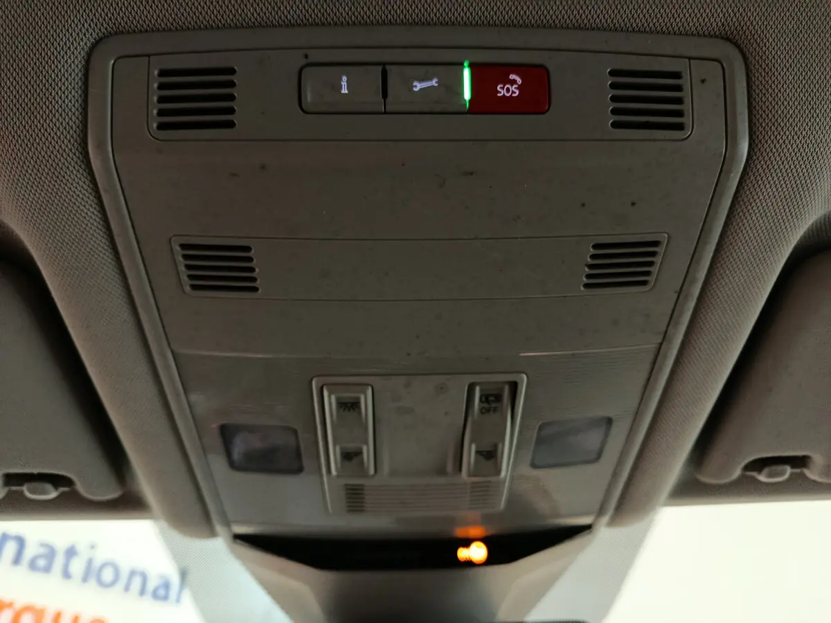 Vue rapprochée du plafonnier intérieur gris clair du Volkswagen T-Roc 2021 avec boutons SOS et éclairage d'ambiance allumé.