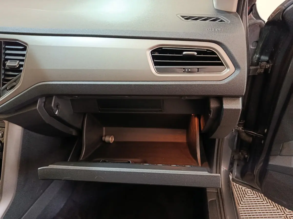 Vue intérieure côté passager du tableau de bord gris foncé et boîte à gants ouverte du Volkswagen T-Roc 2021.