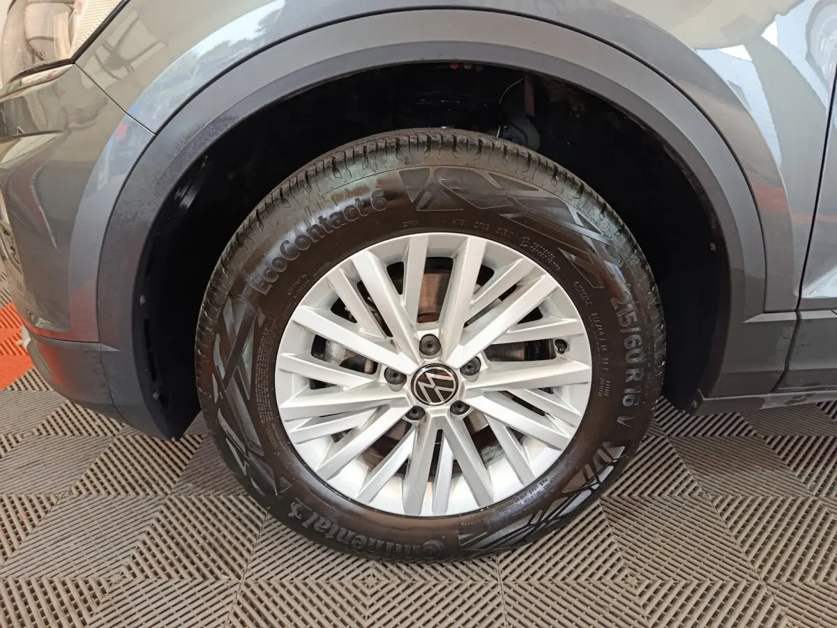 Gros plan sur la roue avant gauche grise du Volkswagen T-Roc 1.0 TSI 110 Lounge Business avec jante alliage argentée.