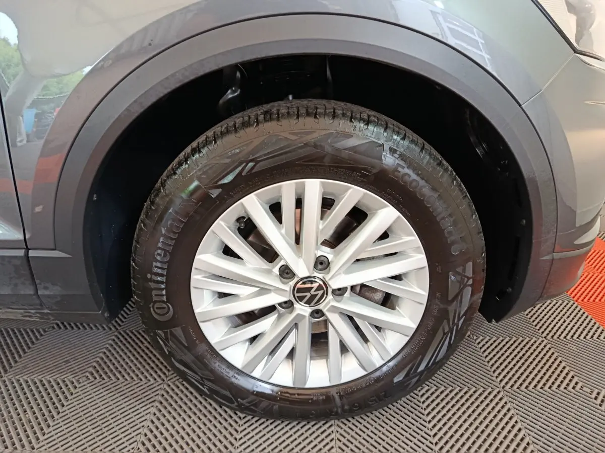 Gros plan sur la roue avant gauche du Volkswagen T-Roc gris foncé avec jante alliage et pneu Continental.