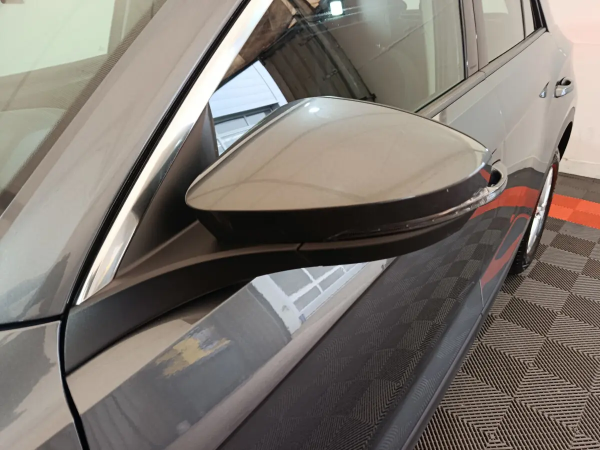 Rétroviseur côté gauche gris foncé du Volkswagen T-Roc 2021 avec clignotant intégré, vue rapprochée en intérieur.