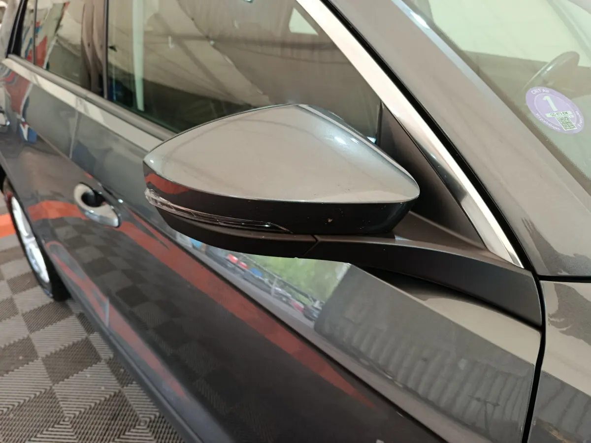 Rétroviseur côté gauche gris foncé du Volkswagen T-Roc 2021, avec poignée de porte et partie de la portière visible.