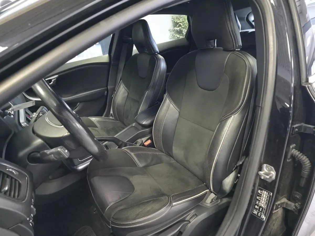 Vue intérieure côté conducteur d'une Volvo V40 D2 R-Design 2019 noire, sièges sport cuir et alcantara avec surpiqûres beige.