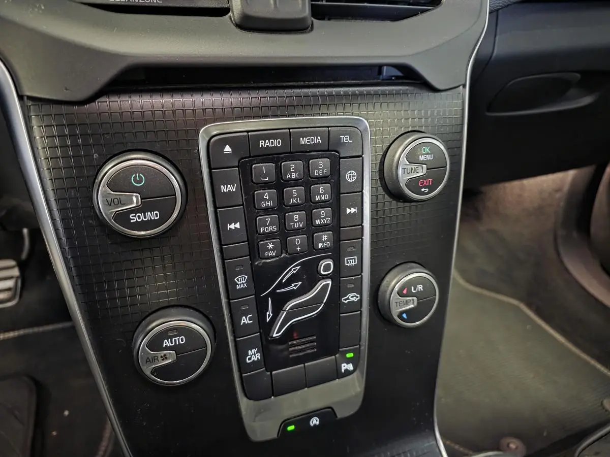 Gros plan sur la console centrale noire de la Volvo V40 D2 R-Design 2019 avec commandes de climatisation et audio.