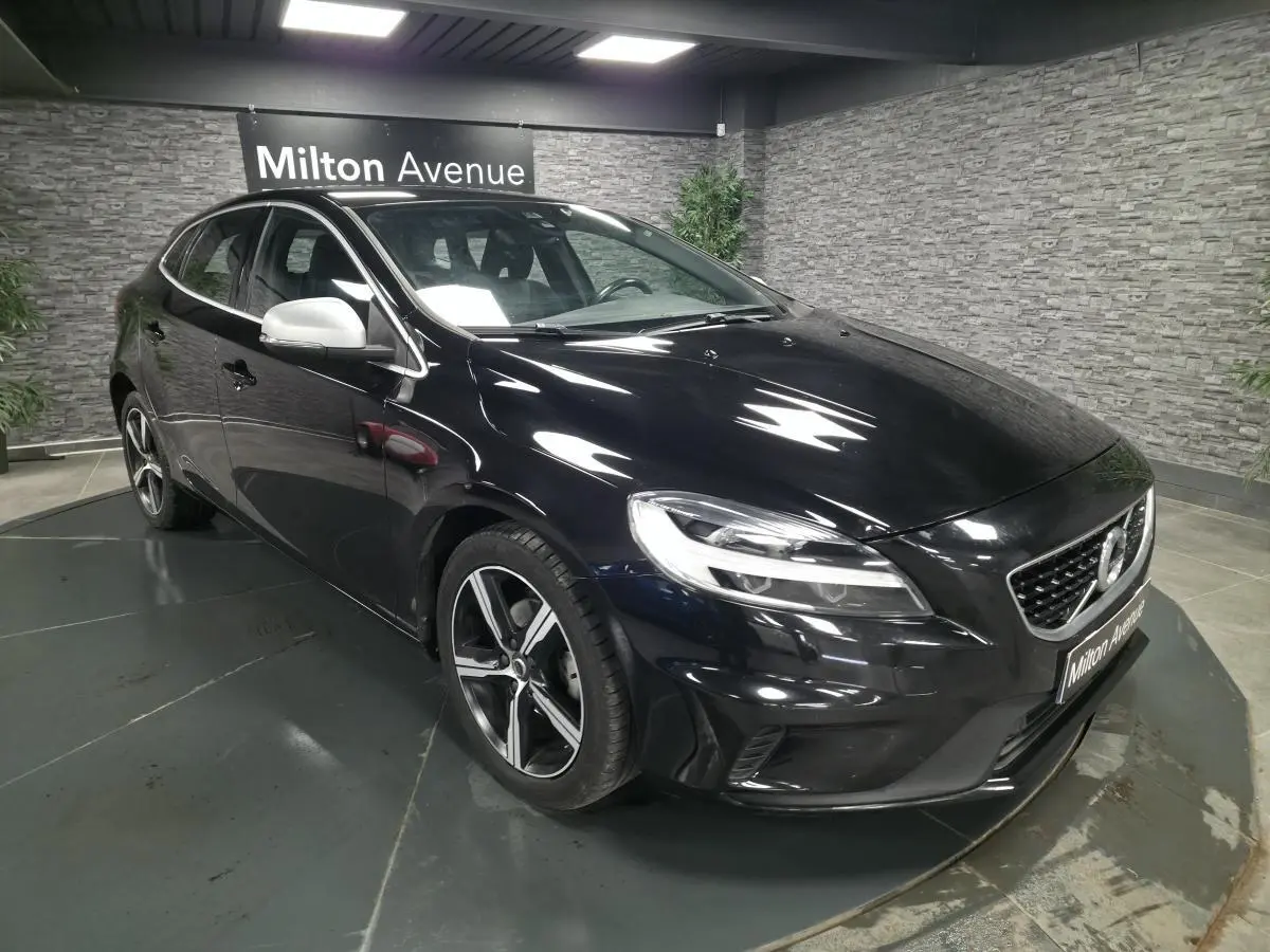 Volvo V40 D2 R-Design noire vue en 3/4 avant avec jantes alliage IXION et coques de rétroviseurs argentées.