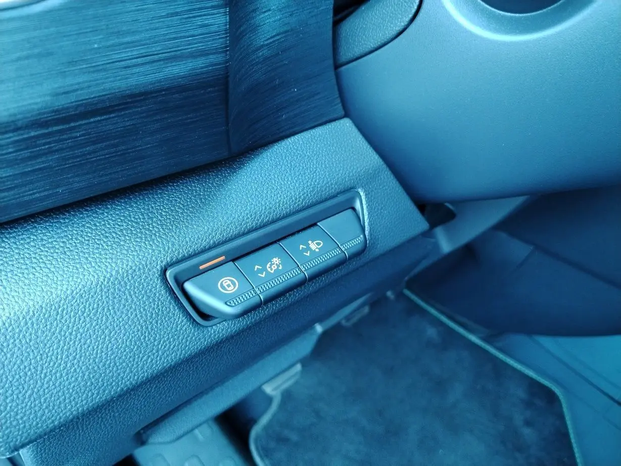 Boutons de réglage d'éclairage et verrouillage sur la planche de bord noire du Nissan Primastar blanc, vue intérieure côté conducteur.