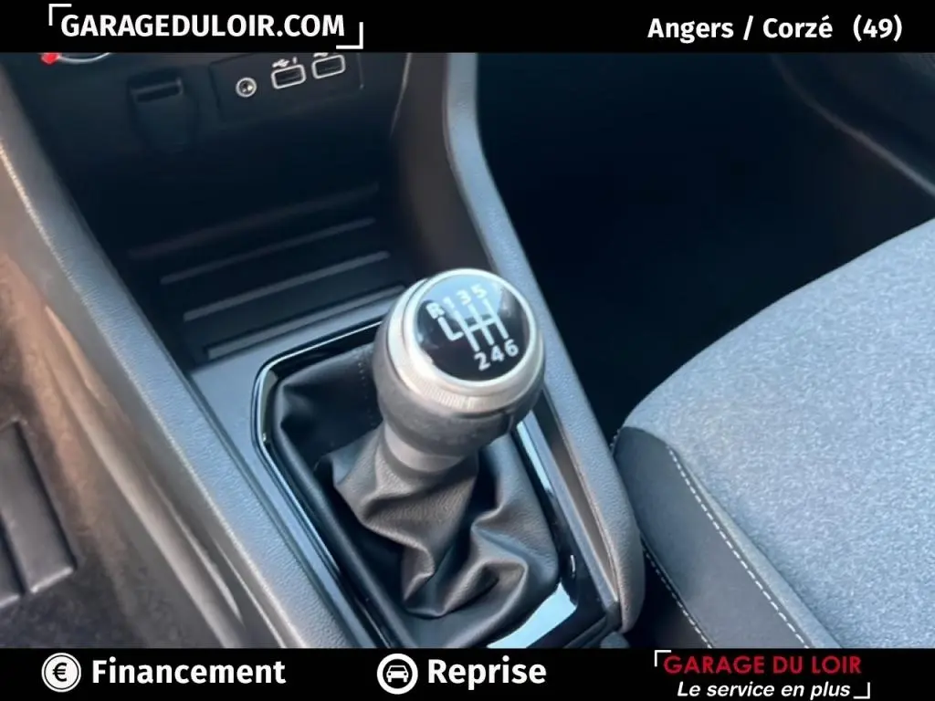 Gros plan sur le levier de vitesse manuel noir et argenté de la Renault Clio Evolution TCe 90, intérieur gris et noir.