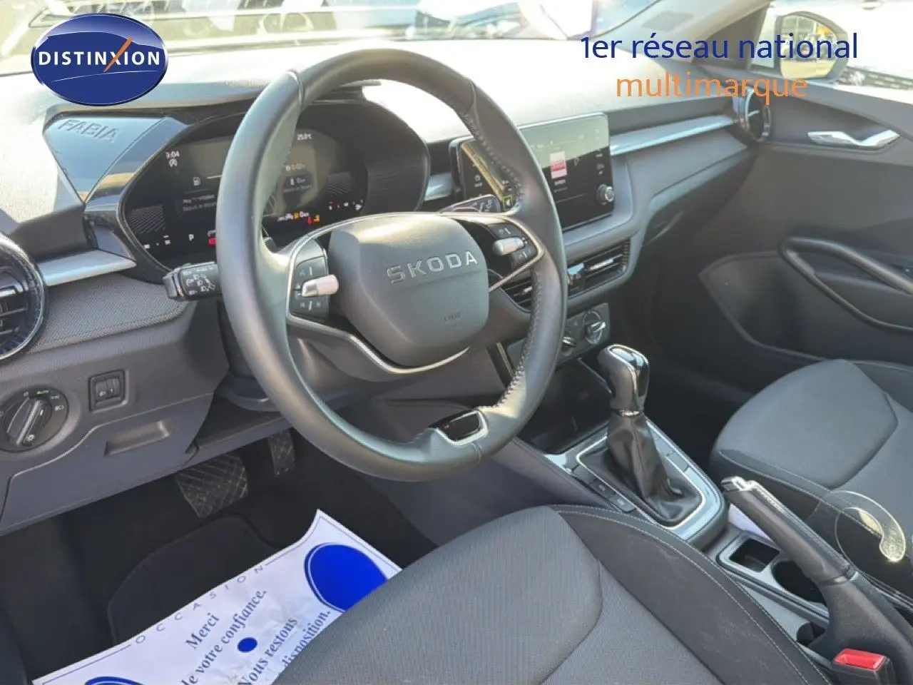 Vue intérieure côté conducteur de la Skoda Fabia 2025 avec volant multifonction, tableau de bord digital et sellerie tissu noir.