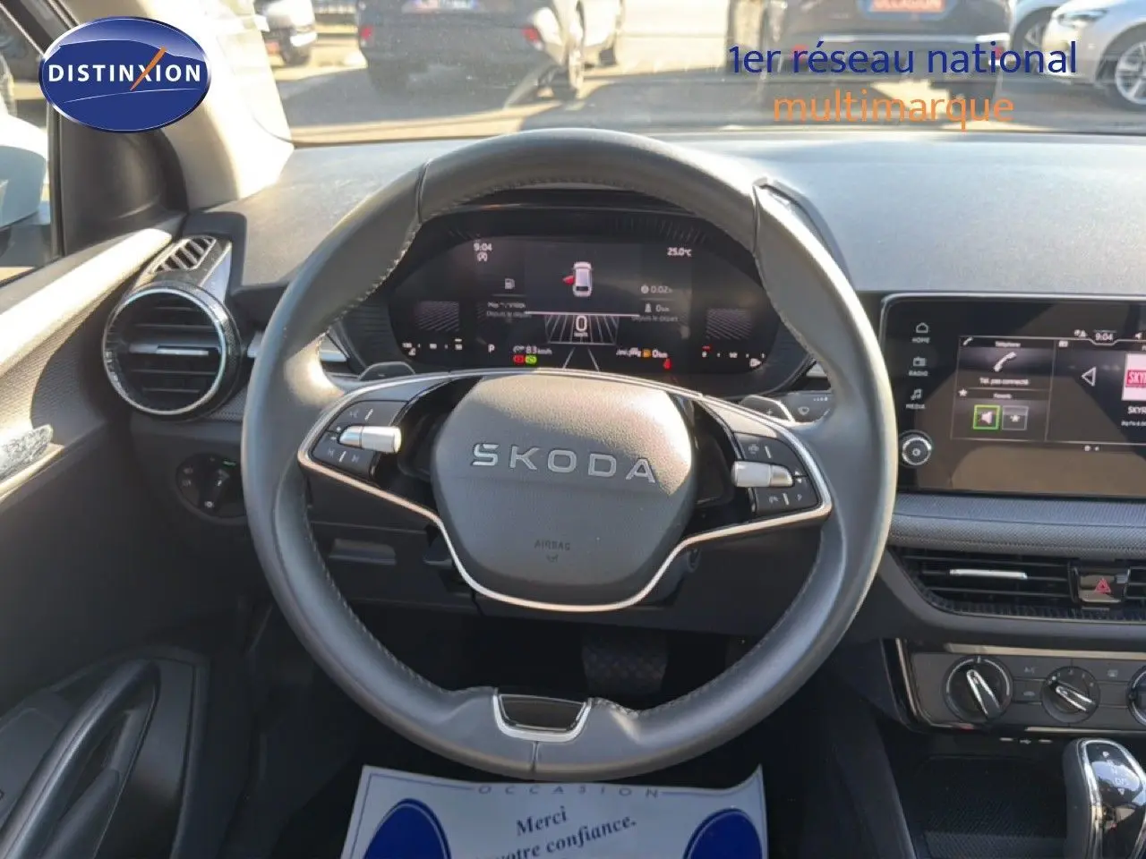 Vue centrée sur le volant noir cuir de la Skoda Fabia 2025 avec tableau de bord numérique et écran tactile.