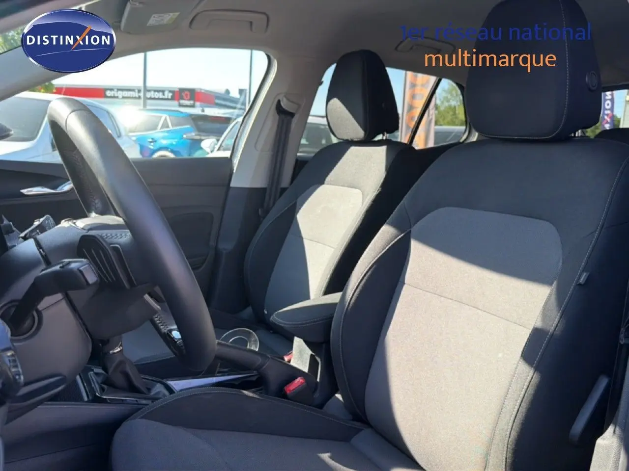 Vue intérieure côté conducteur de la Skoda Fabia 2025 gris graphite, montrant les sièges en tissu et le volant multifonction cuir.