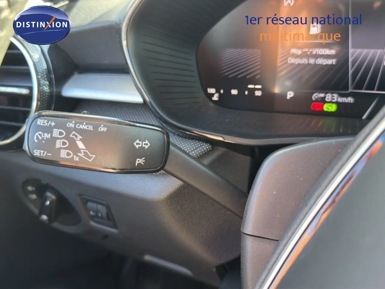 Gros plan sur la commande de régulateur de vitesse à gauche du volant dans l’habitacle gris foncé d’une Skoda Fabia 2025.