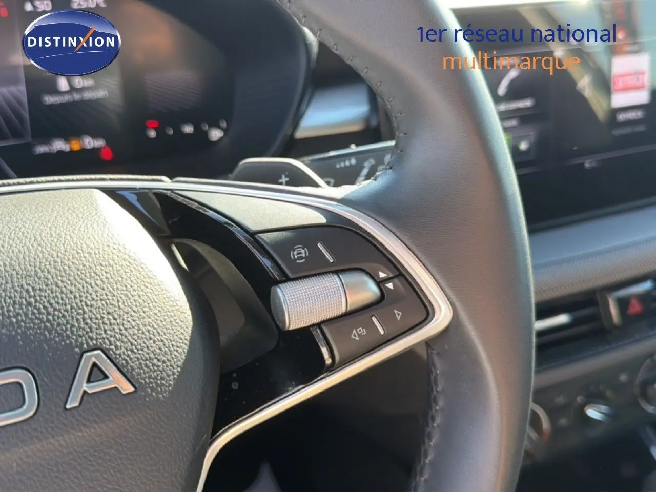 Gros plan sur le volant en cuir noir et la commande de boîte automatique d'une Skoda Fabia gris graphite.