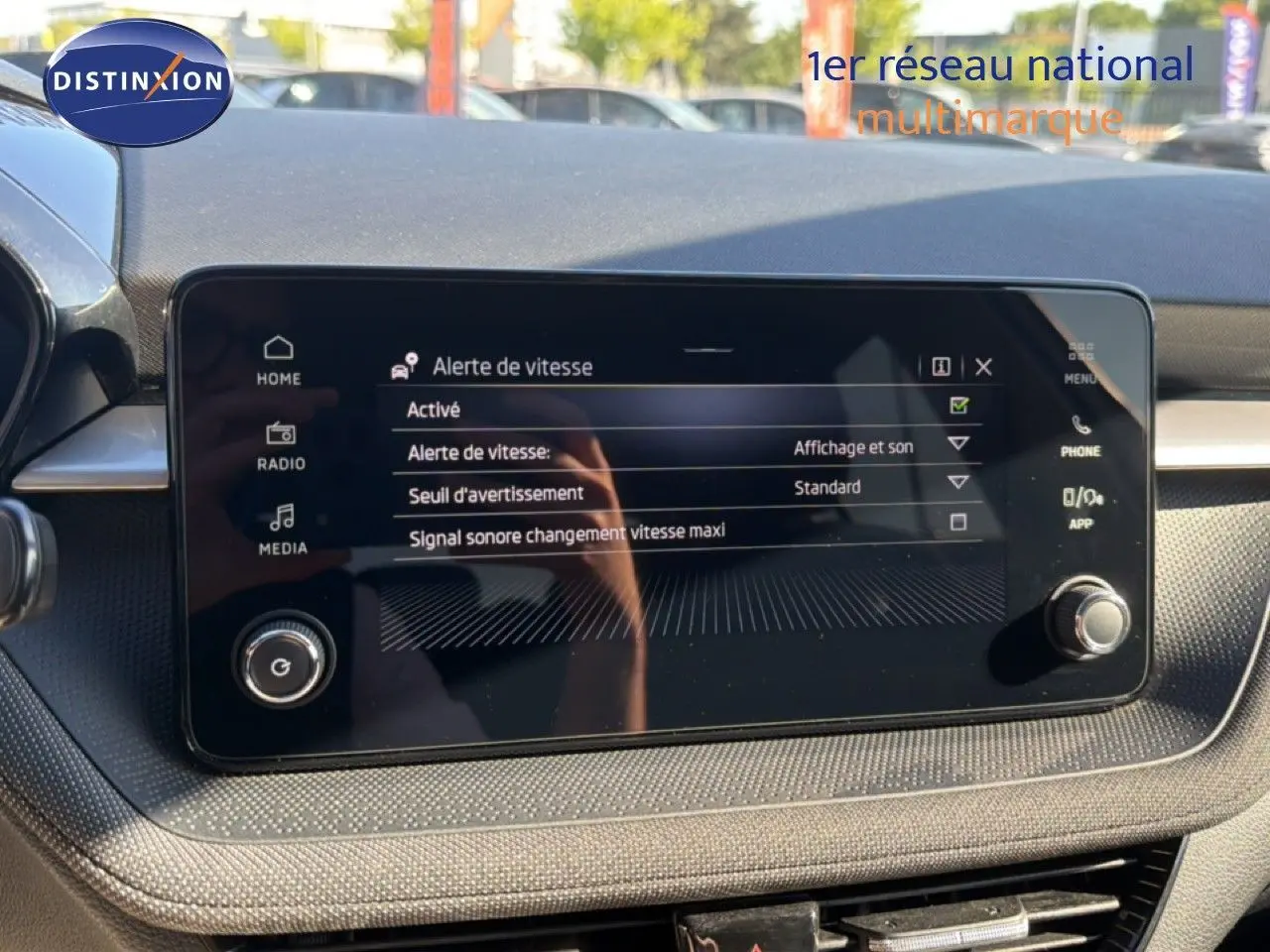 Vue rapprochée de l’écran tactile central du tableau de bord d’une Skoda Fabia gris graphite, affichant la radio FM/DAB.
