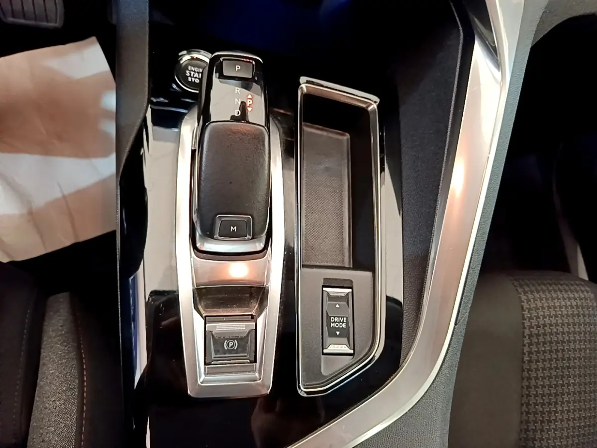 Gros plan sur la console centrale noire du Peugeot 3008 2022 avec levier de vitesse automatique et bouton Drive Mode.