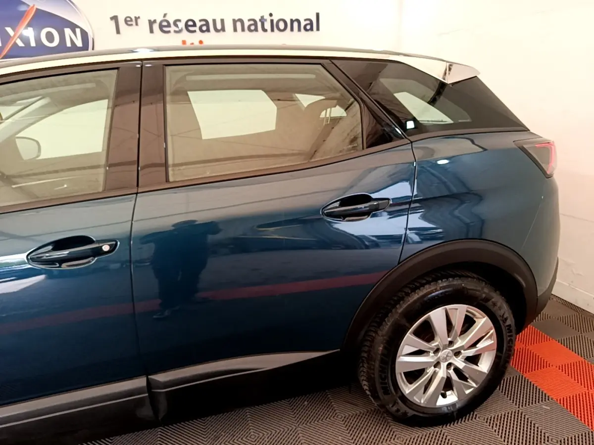 Vue latérale côté droit du Peugeot 3008 bleu 2022 avec toit blanc et jantes alliage visibles.