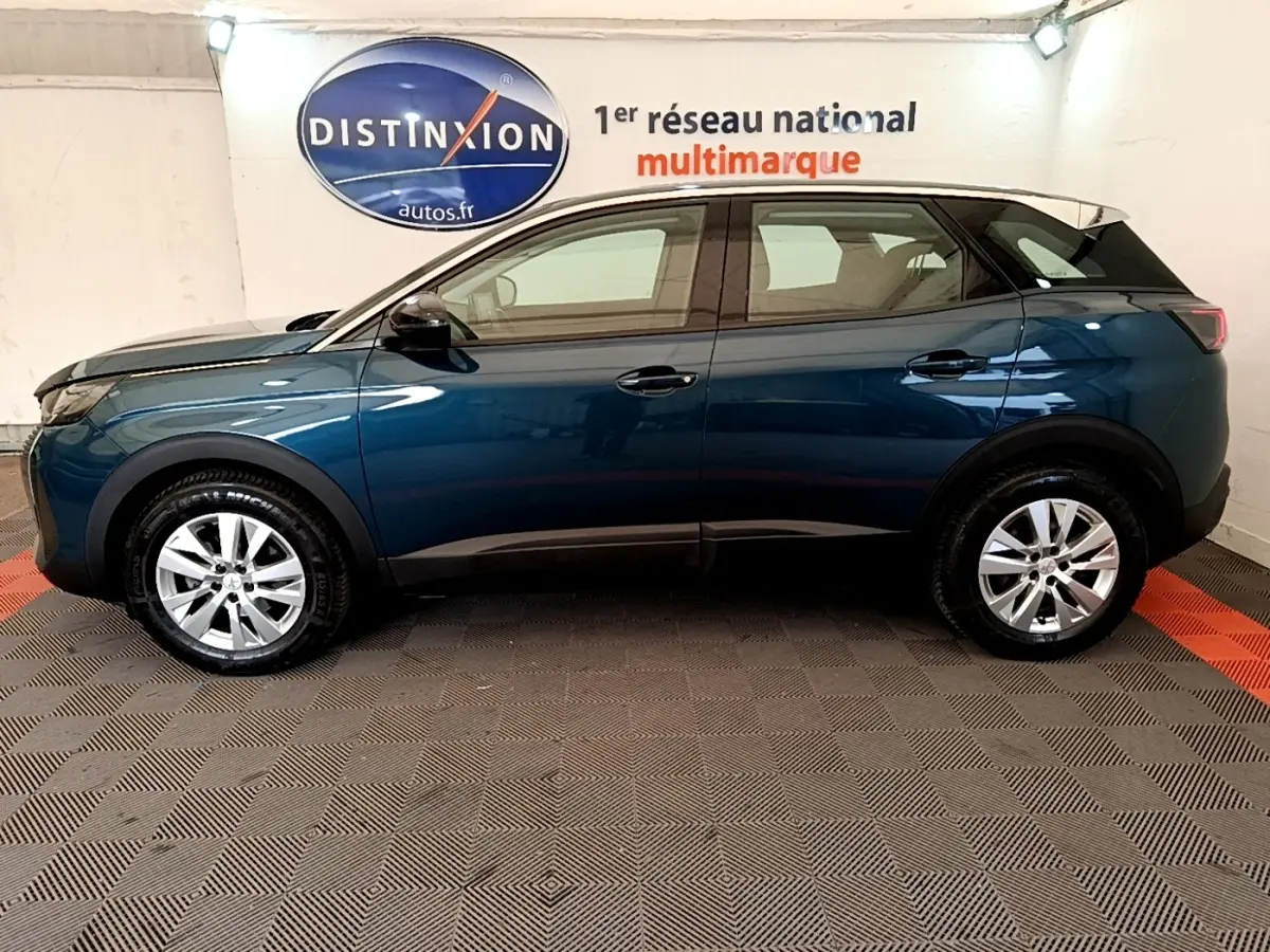 Vue latérale droite d'un Peugeot 3008 bleu 2022 en intérieur, avec toit noir et jantes argentées.