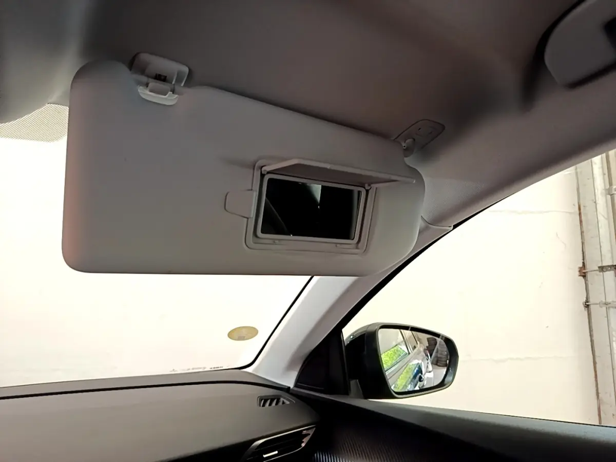 Intérieur du Peugeot 3008 bleu, vue côté gauche sur pare-soleil avec miroir et rétroviseur extérieur.