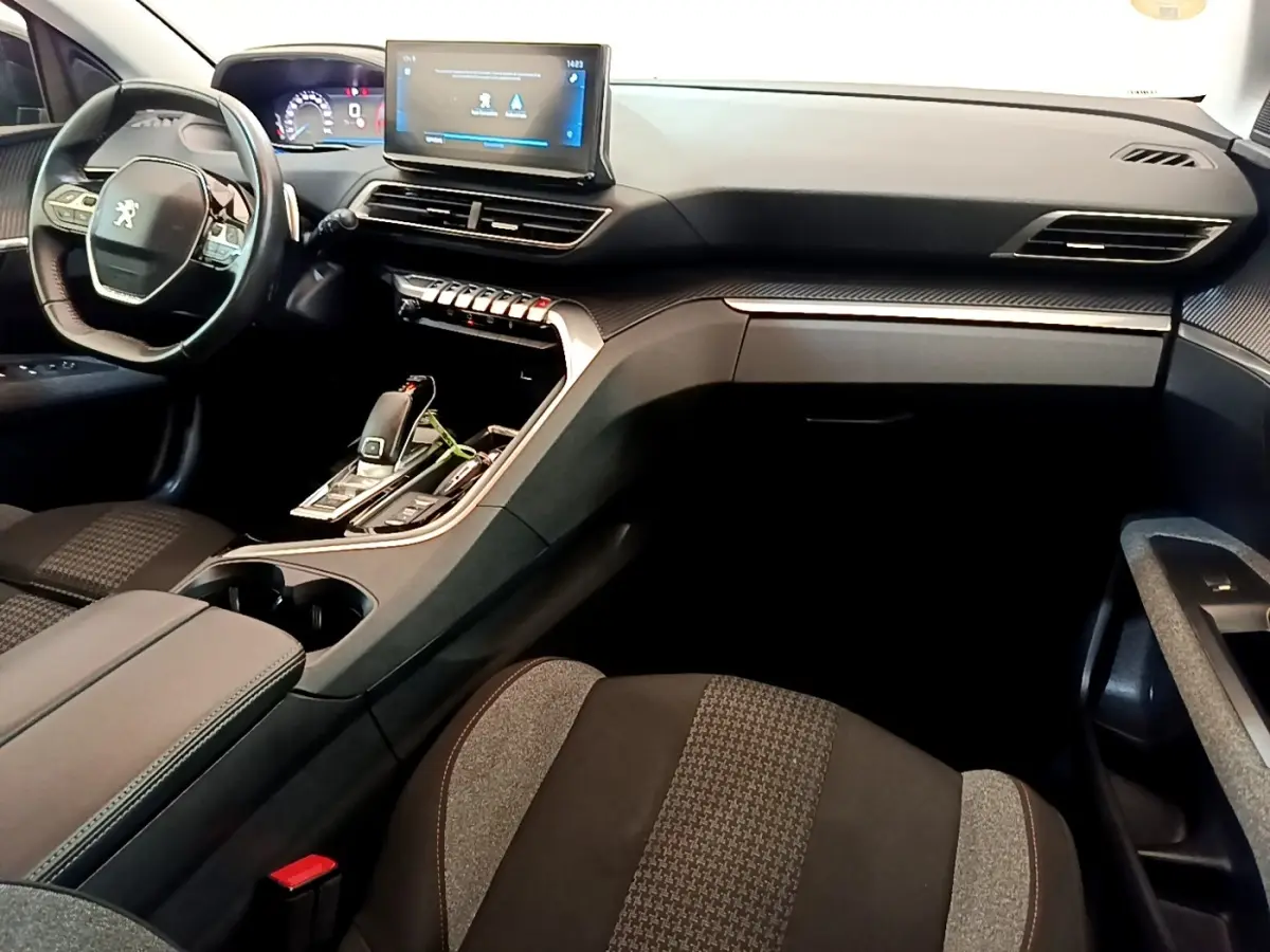 Vue intérieure côté conducteur du Peugeot 3008 bleu, mettant en valeur le tableau de bord digital et l'écran tactile central.