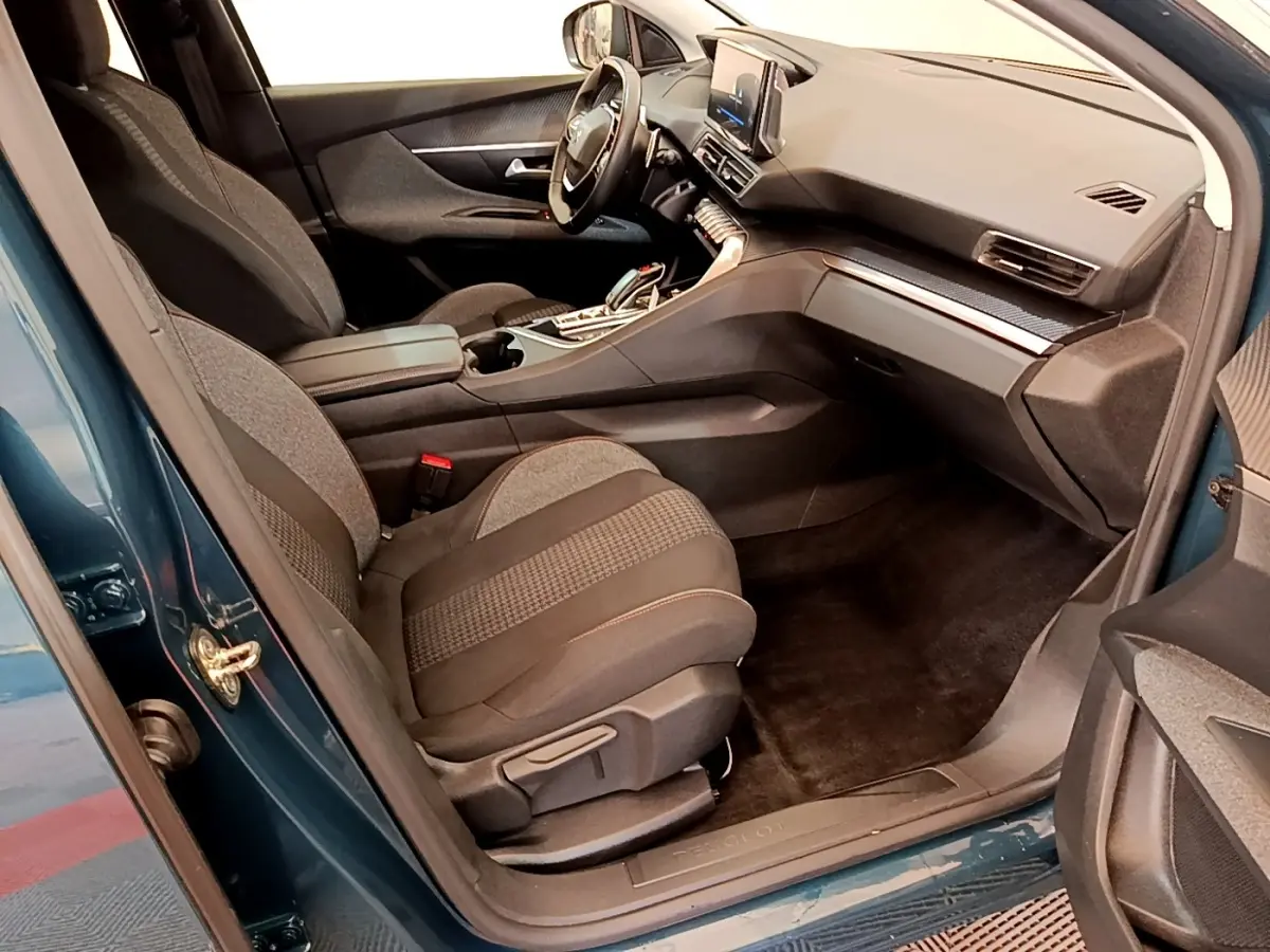 Vue intérieure côté conducteur du Peugeot 3008 bleu, mettant en valeur les sièges et le tableau de bord moderne.