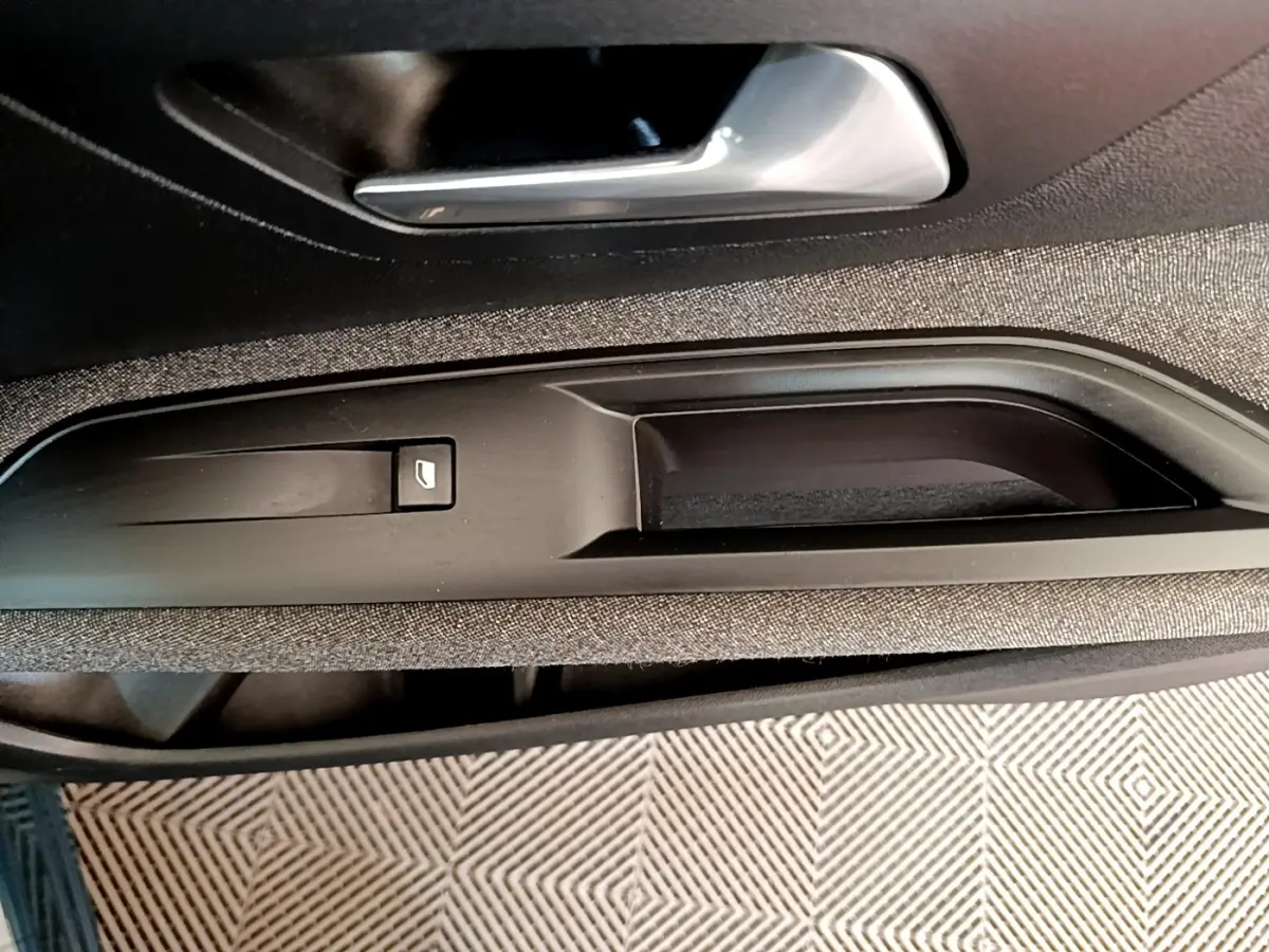 Gros plan sur la poignée intérieure et commande de lève-vitre côté gauche du PEUGEOT 3008 bleu, finition Active Pack 2022.