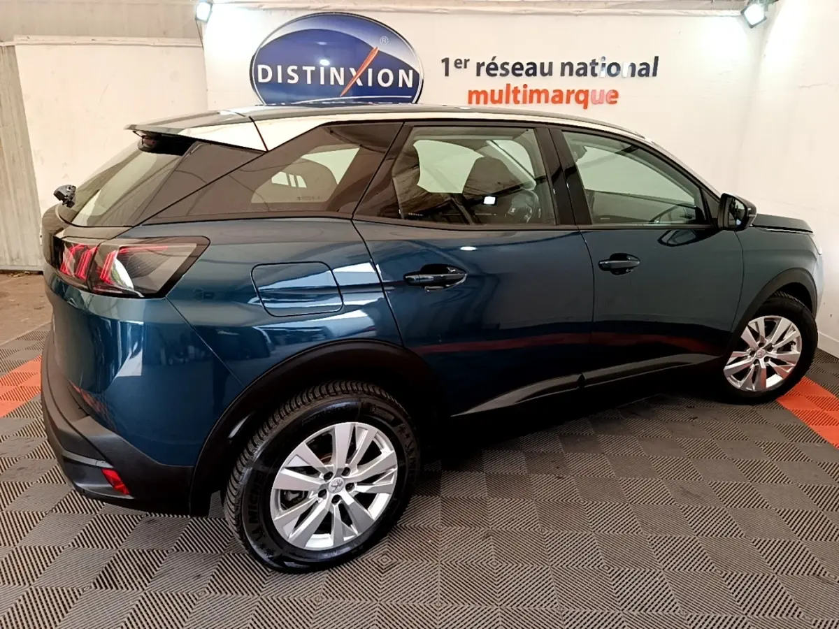 Vue 3/4 arrière droite du Peugeot 3008 bleu 2022 avec toit noir et jantes alliage argentées.
