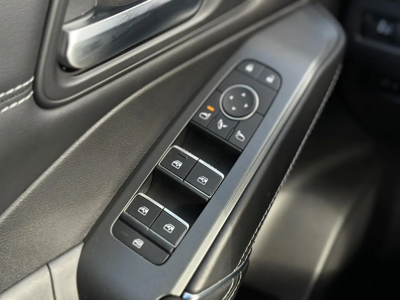 Gros plan sur les commandes des vitres électriques côté gauche intérieur du Nissan Qashqai blanc nacré 2025.