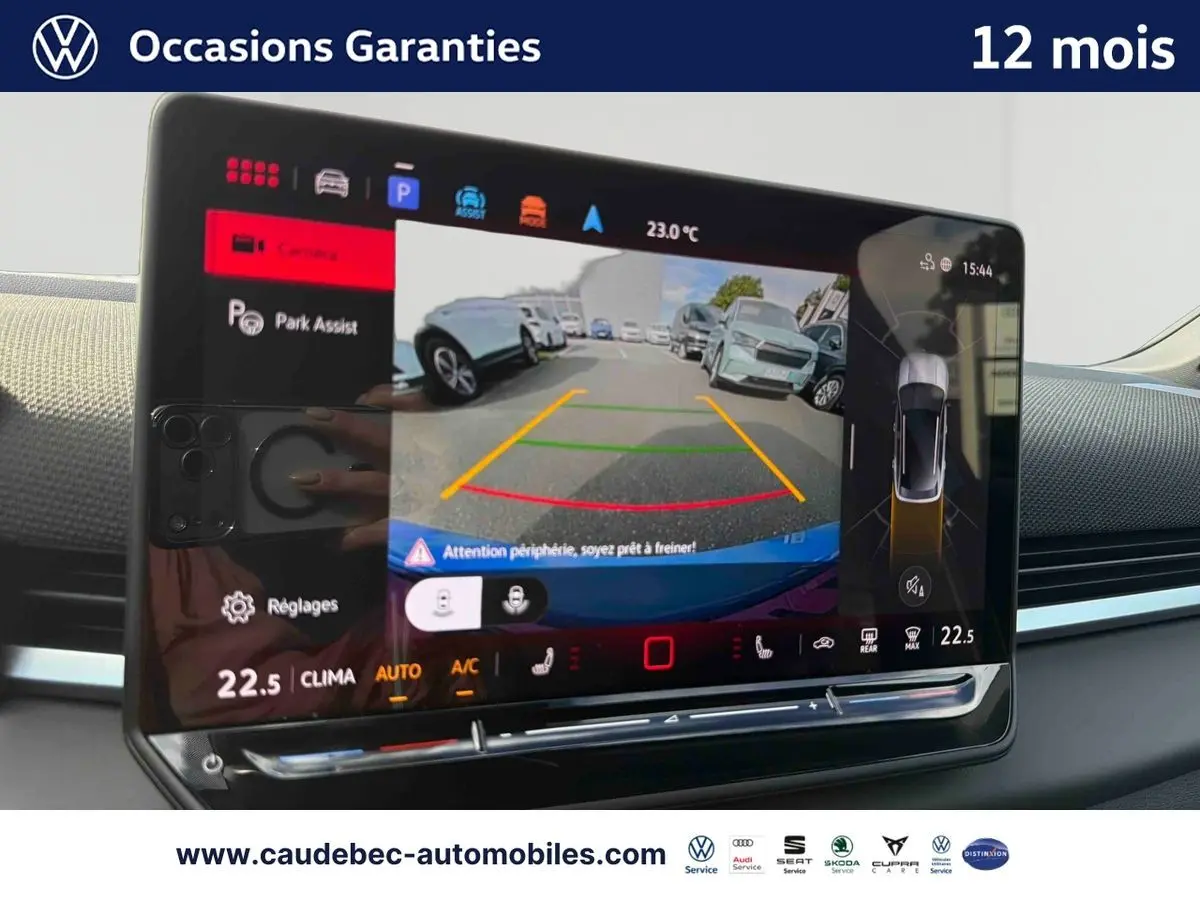 Vue intérieure de l'écran tactile du Volkswagen T-Roc bleu montrant l'assistance au stationnement avec caméra de recul.