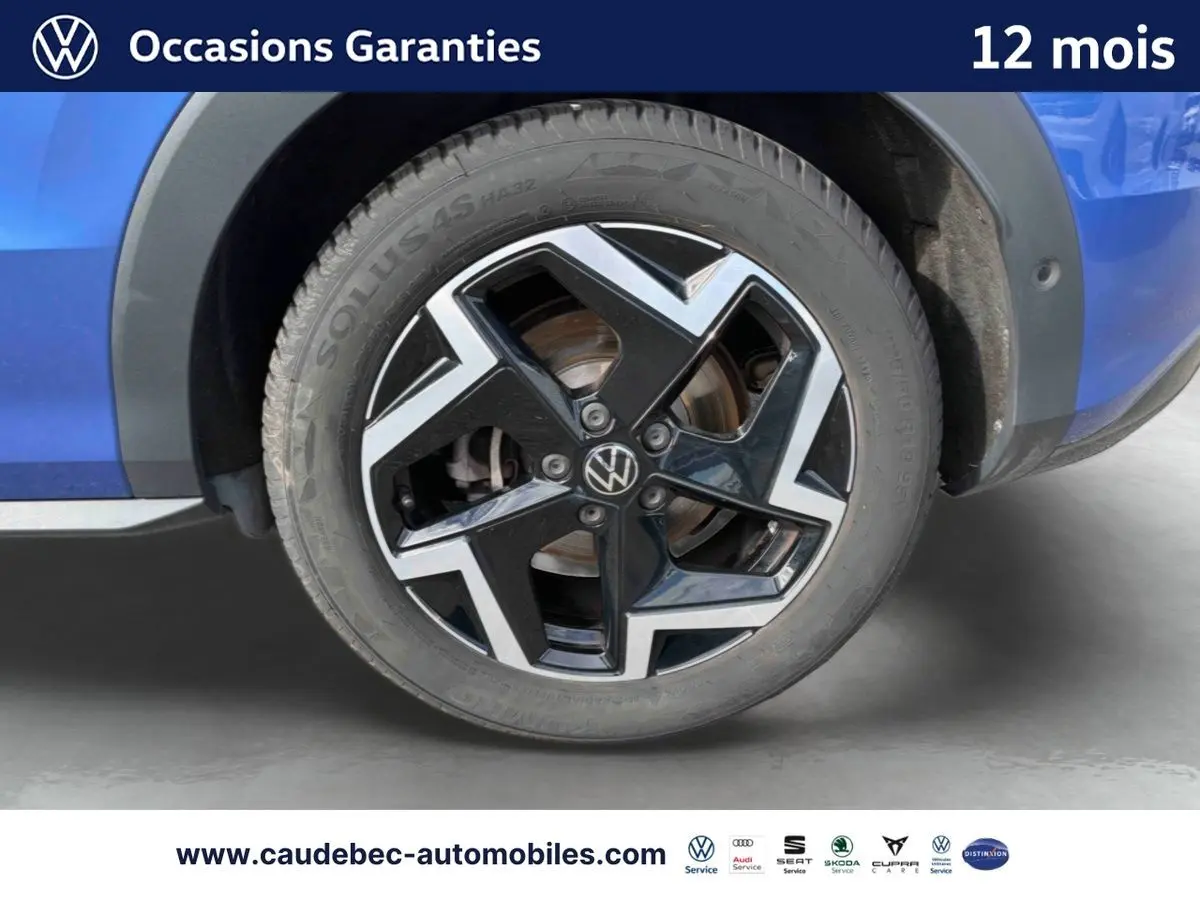 Gros plan sur la jante en alliage noir et argent du côté gauche d’un Volkswagen T-Roc bleu métallisé.
