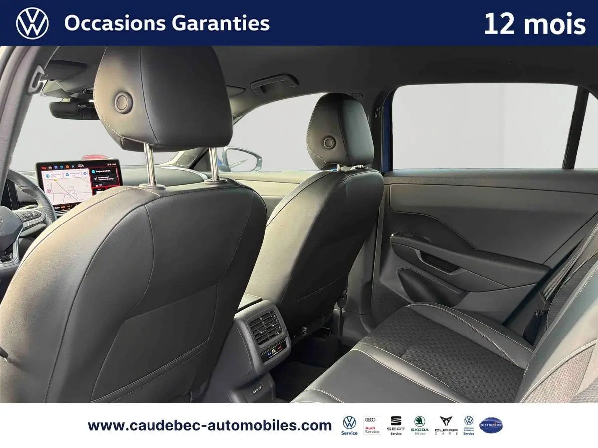 Vue intérieure arrière du Volkswagen T-Roc 2026 avec sièges en cuir noir et tableau de bord digital visible au loin.