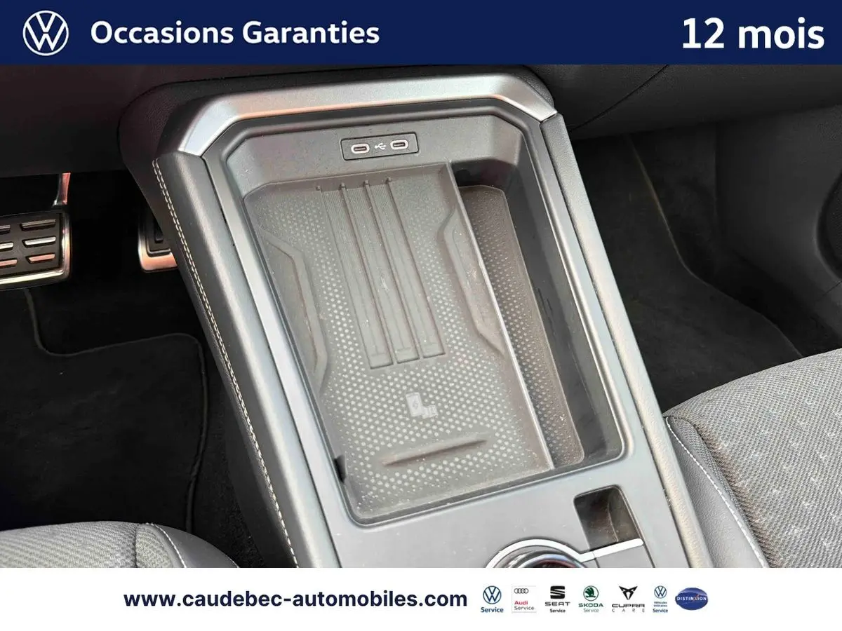 Vue rapprochée de la console centrale du Volkswagen T-Roc 2026 avec zone de recharge sans fil et finition sobre.