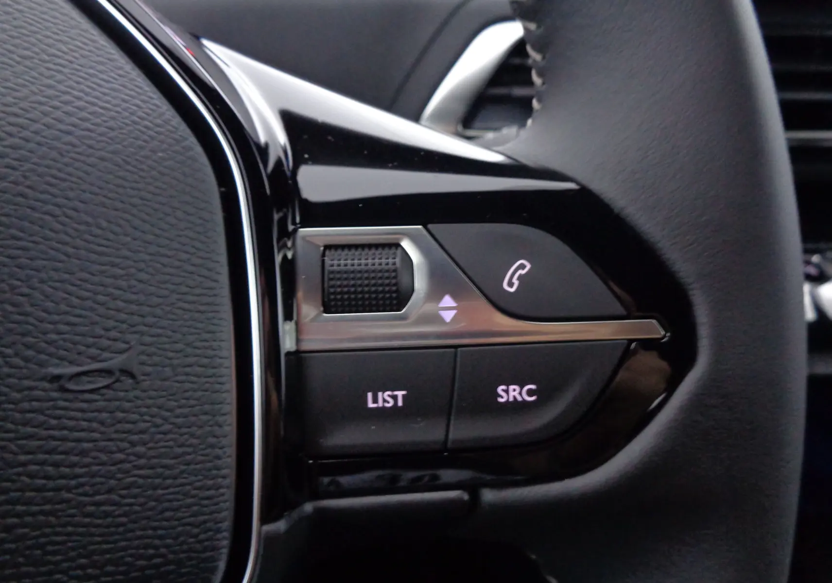 Gros plan sur les commandes gauche du volant du Peugeot 3008 gris Artense, boutons pour téléphone et audio.