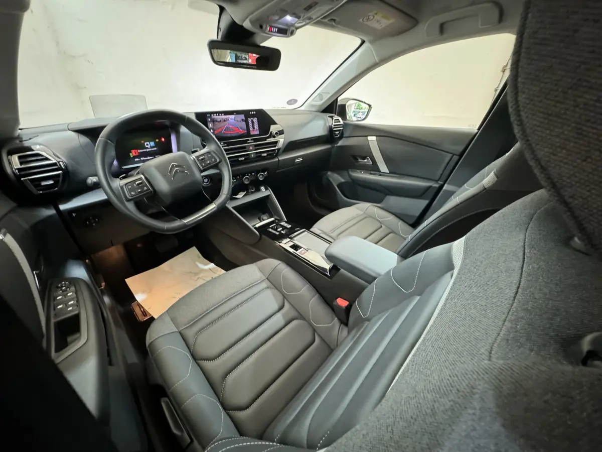 Intérieur de la Citroën C4 PureTech 130 EAT8 Shine 2023, vue côté conducteur, sièges gris et tableau de bord digital.
