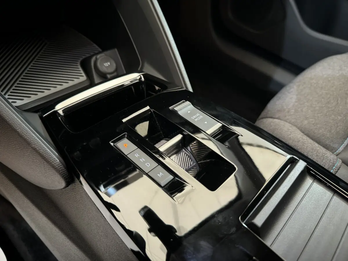 Gros plan sur la console centrale noire brillante de la Citroën C4 PureTech 130 EAT8 Shine avec sélecteur de boîte auto et commande Drive Mode.