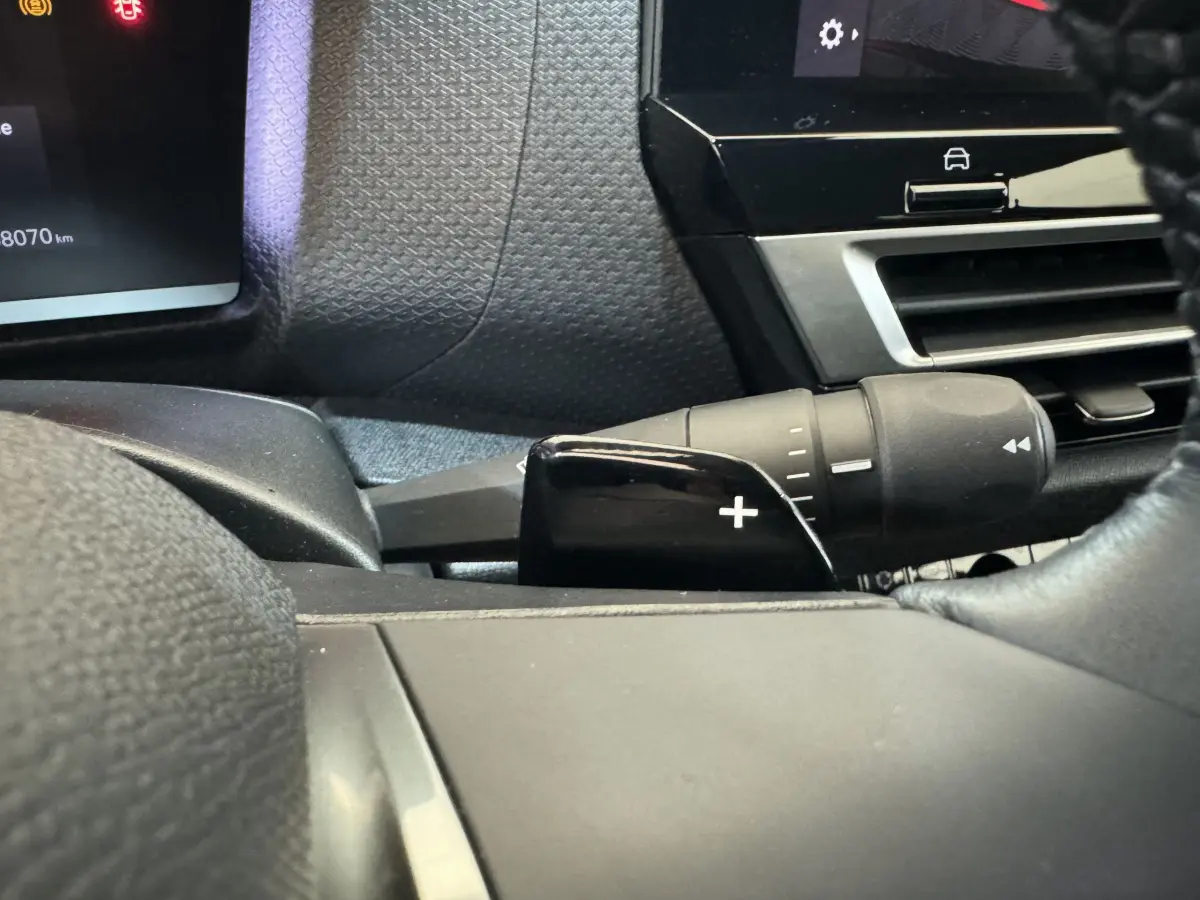 Gros plan sur la commande de palette de changement de vitesse + côté gauche du tableau de bord noir d'une Citroën C4 2023.