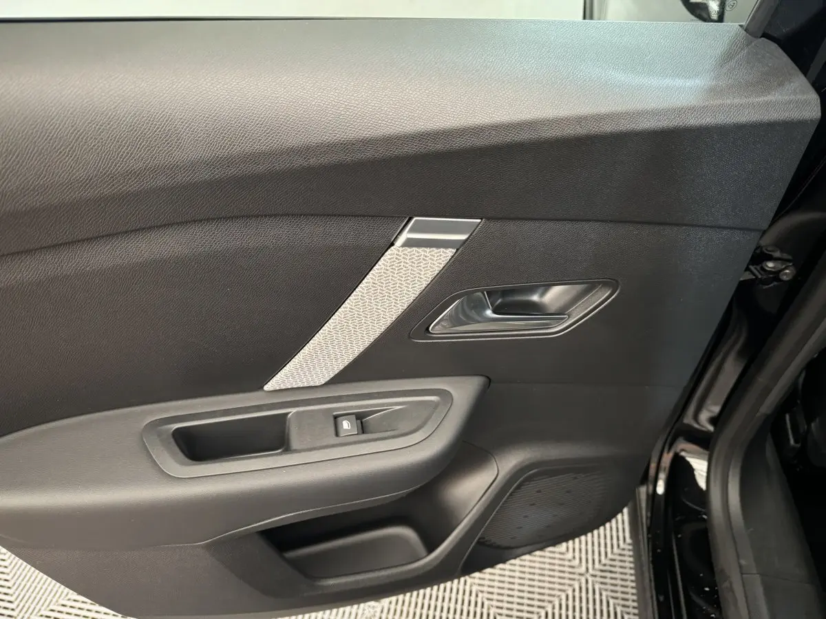 Gros plan sur la porte côté gauche de la Citroën C4 noire 2023, avec poignée argentée et bouton de verrouillage intégré.