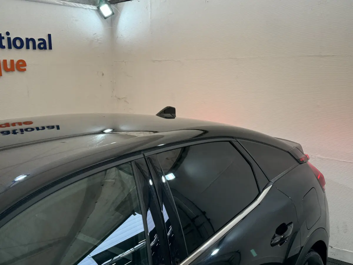 Vue côté droit arrière d'une Citroën C4 PureTech 130 EAT8 Shine noire avec vitres teintées et antenne requin.