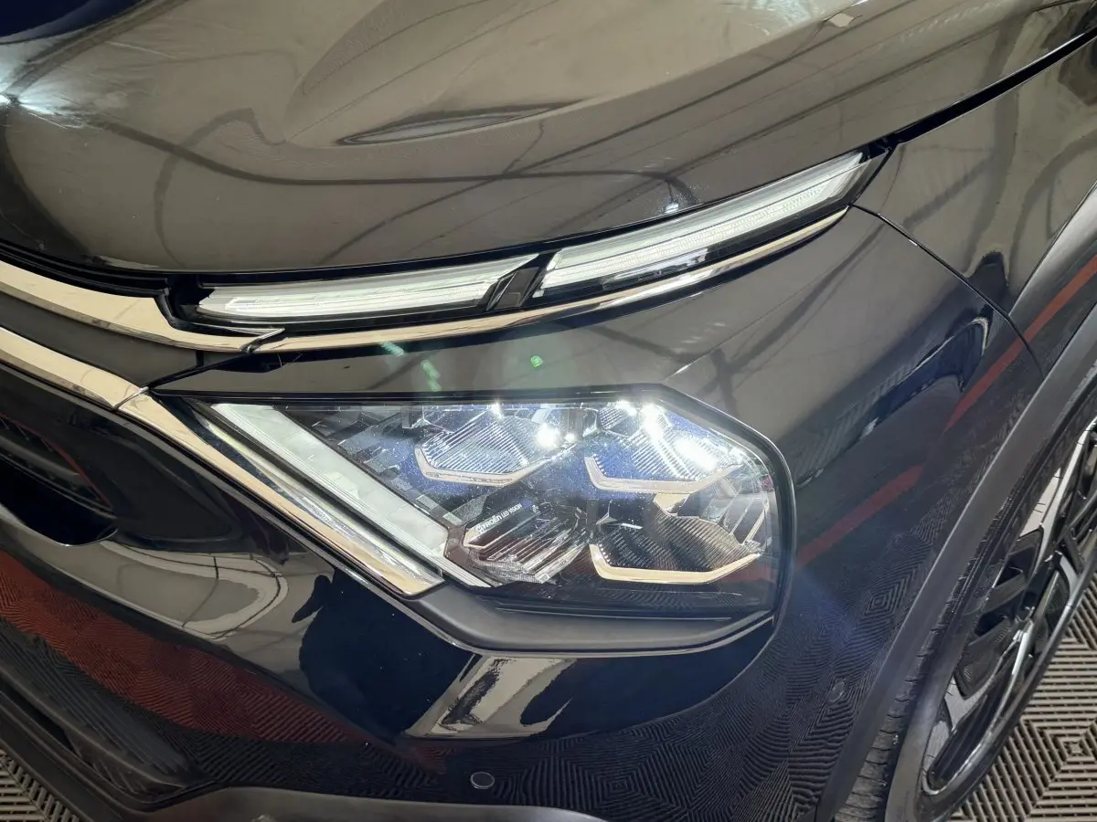 Gros plan sur le phare avant droit LED d'une Citroën C4 noire 2023, soulignant ses lignes modernes et détails chromés.