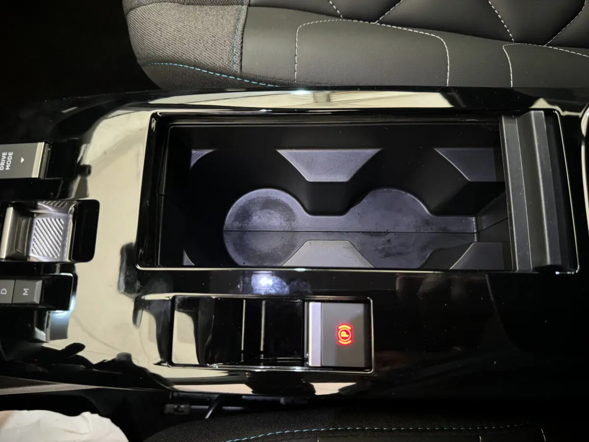 Gros plan sur la console centrale noire de la Citroën C4 PureTech 130 EAT8 Shine avec frein à main électrique activé.