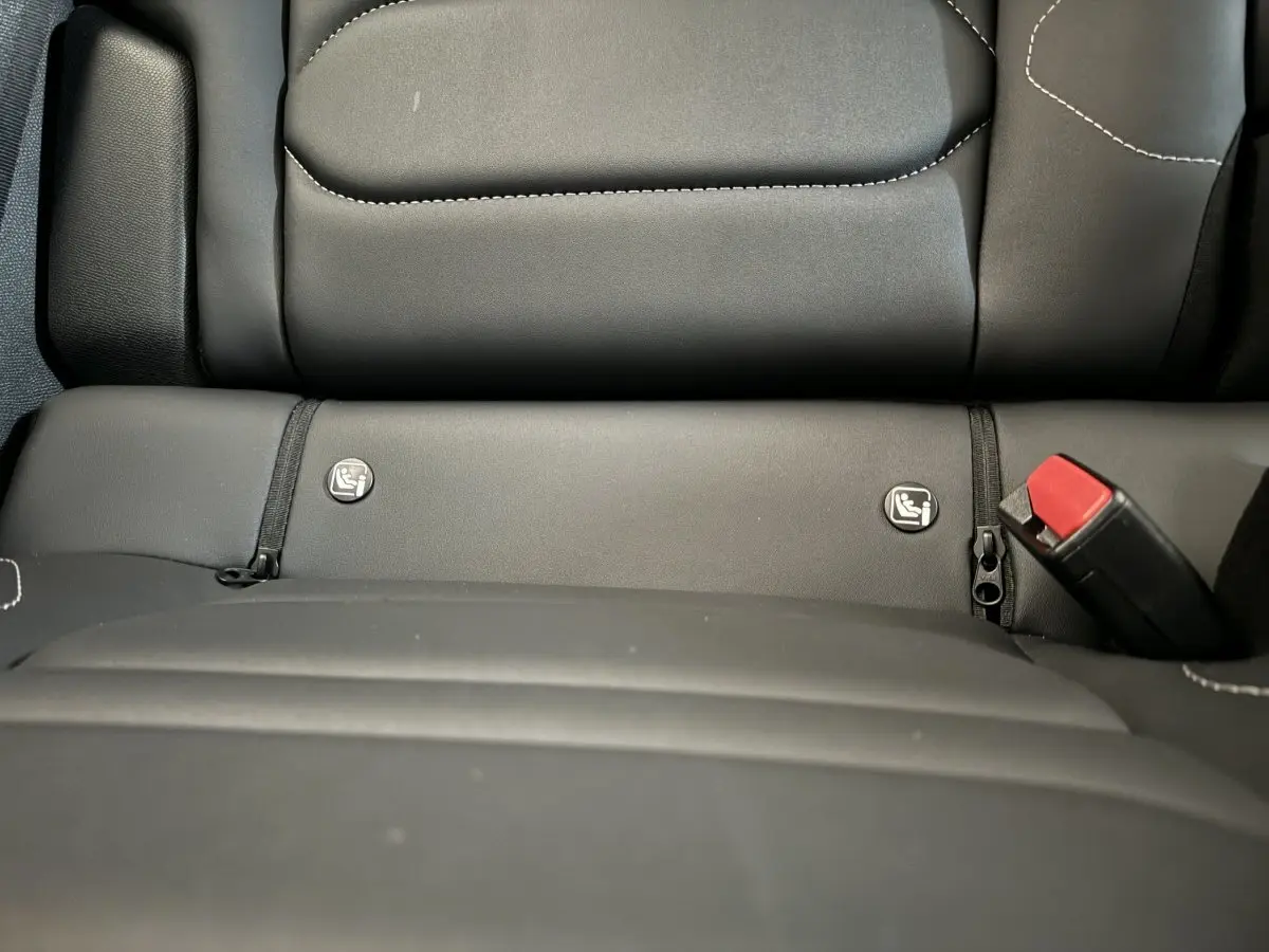 Gros plan sur la banquette arrière noire de la Citroën C4 PureTech 130 EAT8 Shine avec fixation Isofix et ceinture rouge.