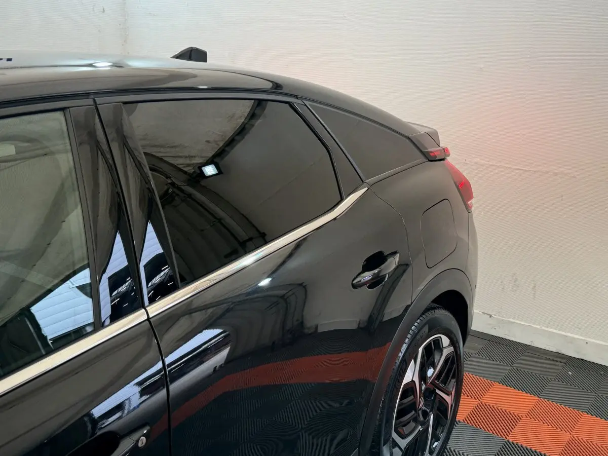 Vue côté arrière droit d'une Citroën C4 PureTech 130 noire, soulignant les vitres teintées et les jantes modernes.