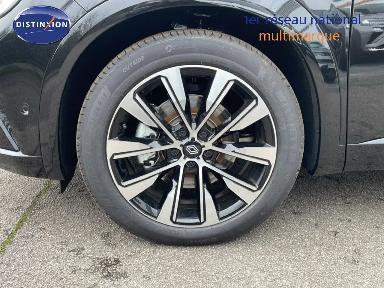 Gros plan sur la roue avant gauche du Renault Espace noir étoile métal avec jante alliage bicolore moderne.