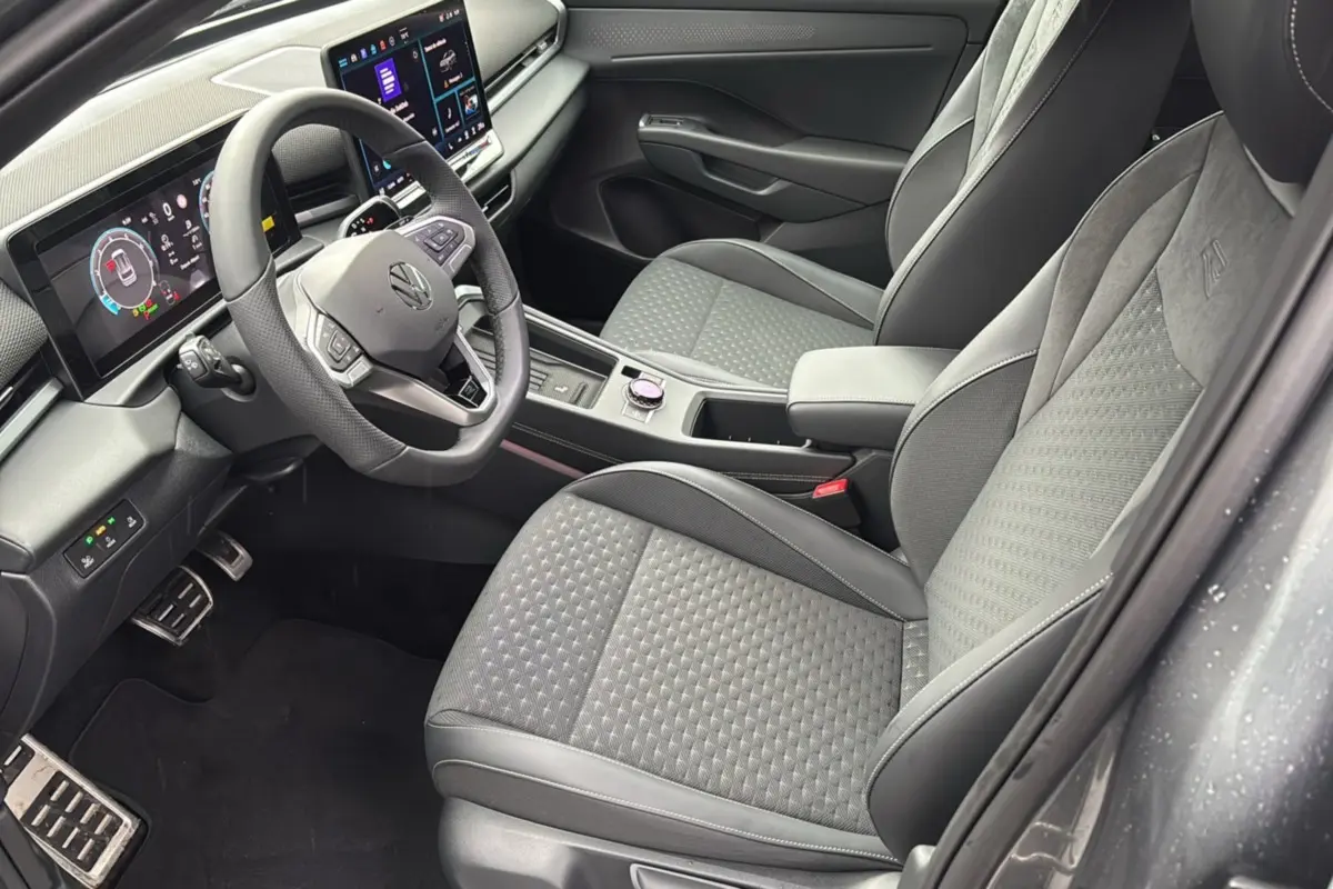 Vue intérieure côté conducteur du Volkswagen T-Roc gris loup 2026, avec sièges tissu R-Line et tableau de bord digital.