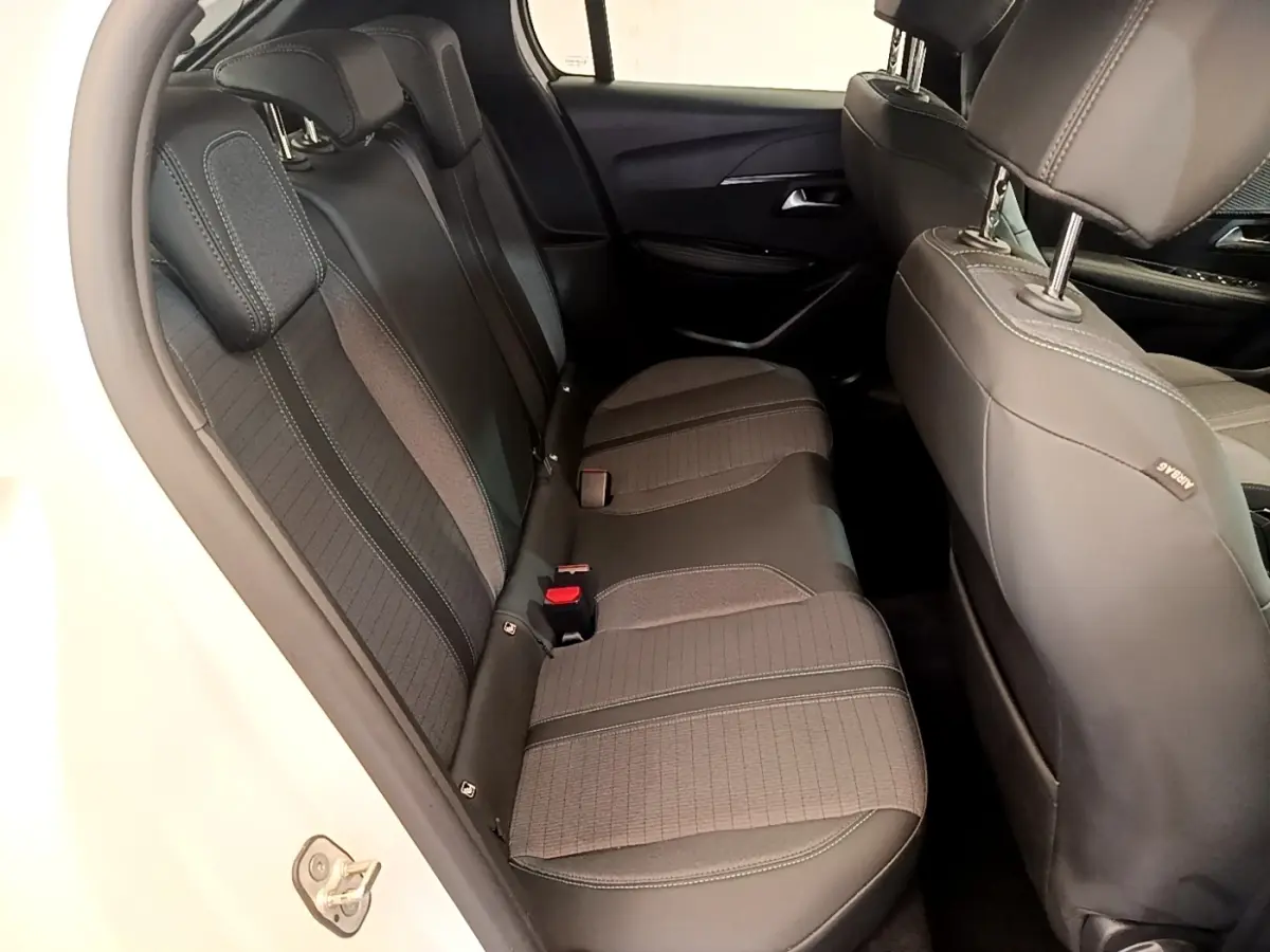 Vue intérieure côté gauche des sièges arrière noirs en tissu et cuir du Peugeot 208 blanc PureTech 100 S&S Allure Business 2021.