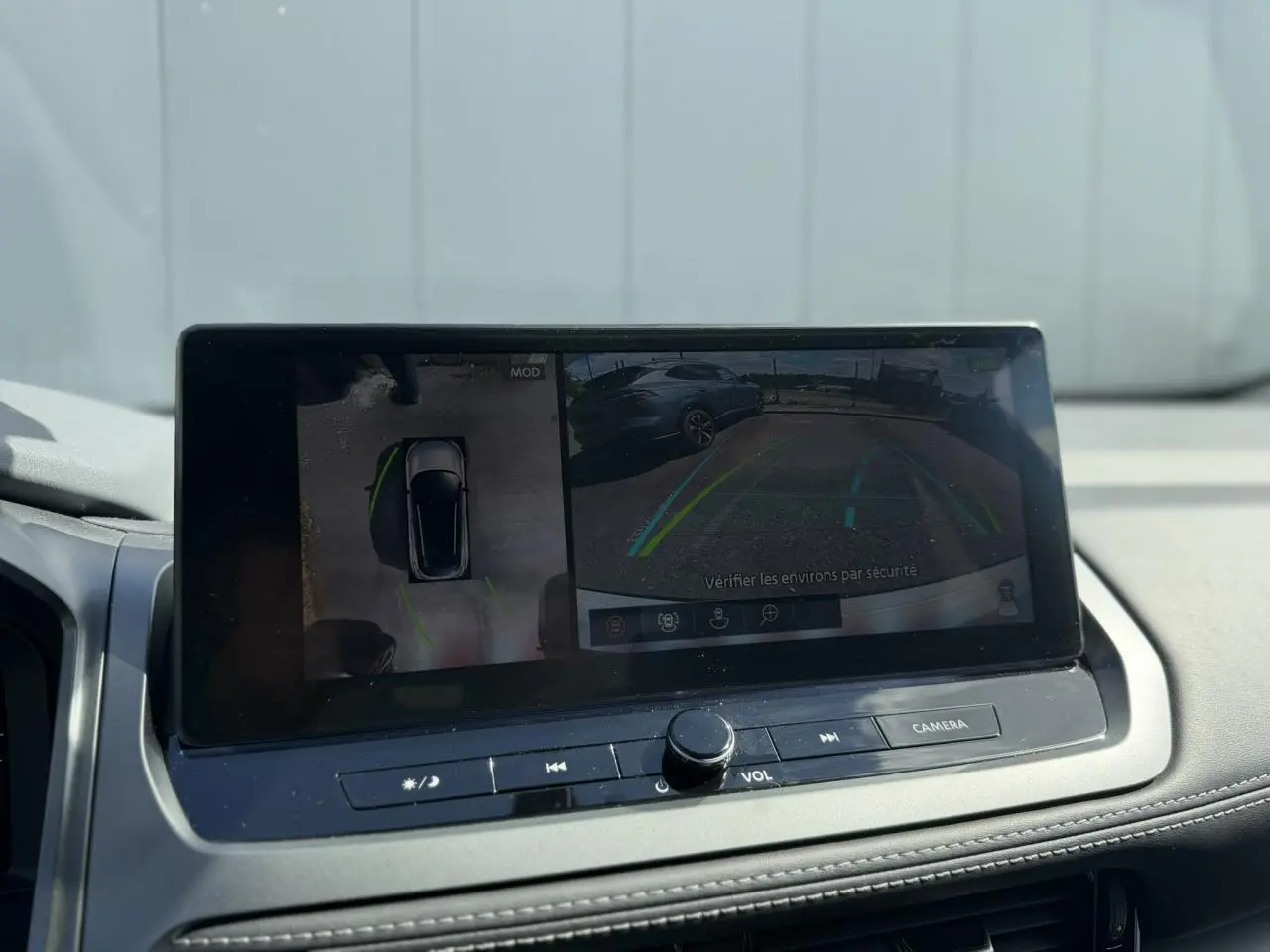 Écran central du Nissan Qashqai 2025 montrant la caméra de recul et la vision 360°, intérieur noir et gris.