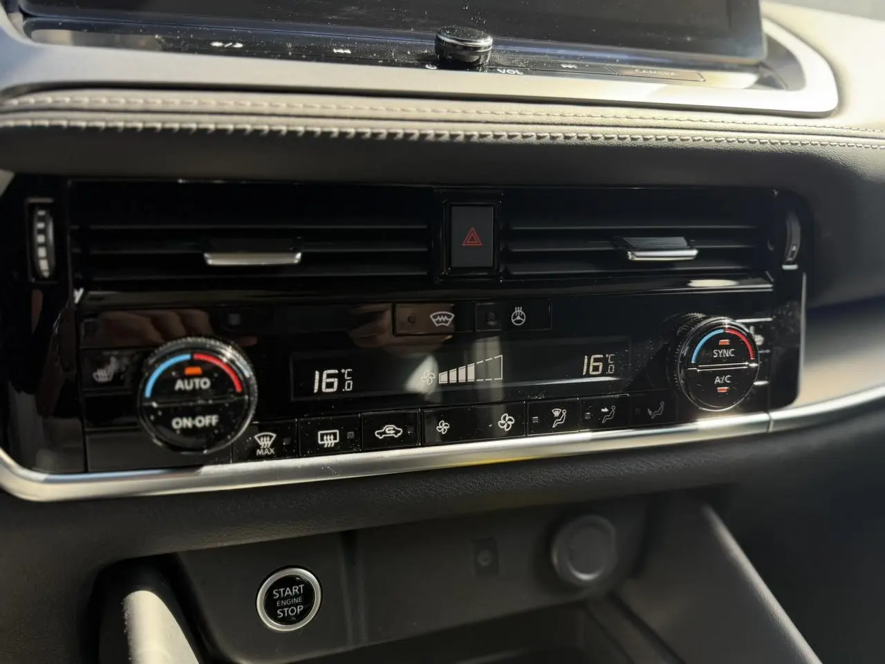 Détail de la console centrale du Nissan Qashqai 2025 montrant la climatisation automatique bi-zone et le bouton Start/Stop.